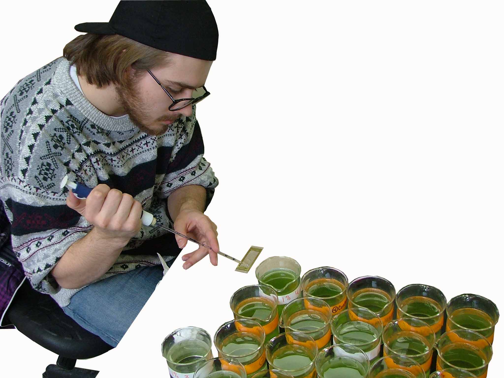 Reese Hussey, biology student participating in the student work on Gooseberry Farm performing tests with hydrogen peroxide on algae that is taking over a pond.