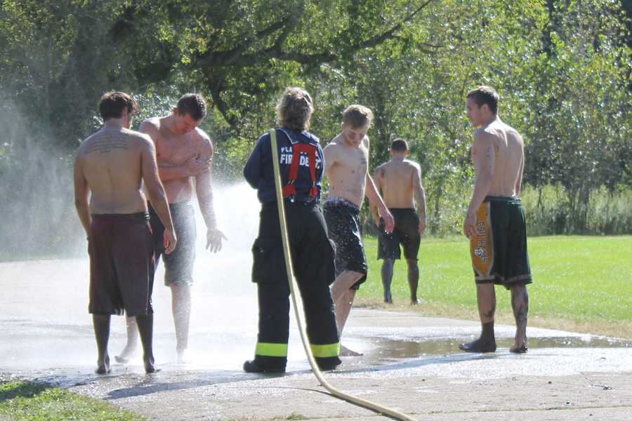 Mud volleyball participants hose off after the event Sept. 21. 