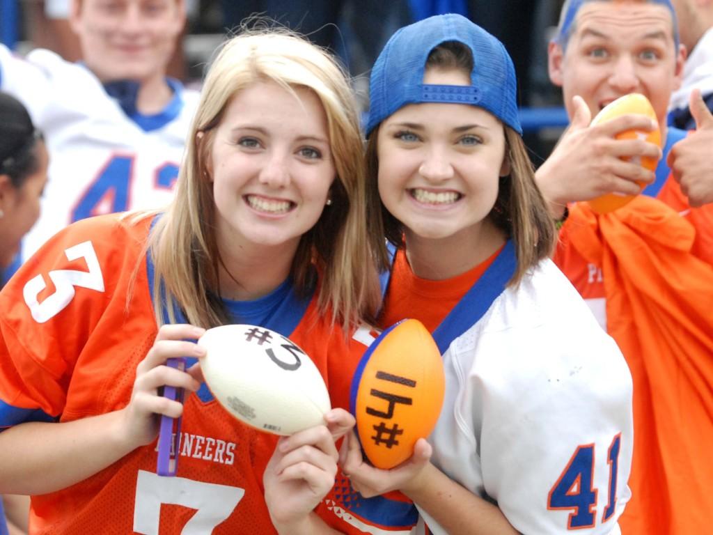 Molly Pearce (left) and Mary Ebeling were chosen to play the Ubersox drive half-time game. They had to throw miniature footballs into the bed of a truck to win a free vehicle detail service.