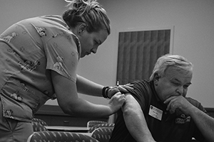 Kim Pribnow gives the vaccination to UW-Platteville employee Bart Johll.