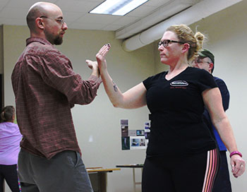 Professor Thomas Pitcher teaches  class participant tai chi move  “Push Hands” during their class on Monday evening