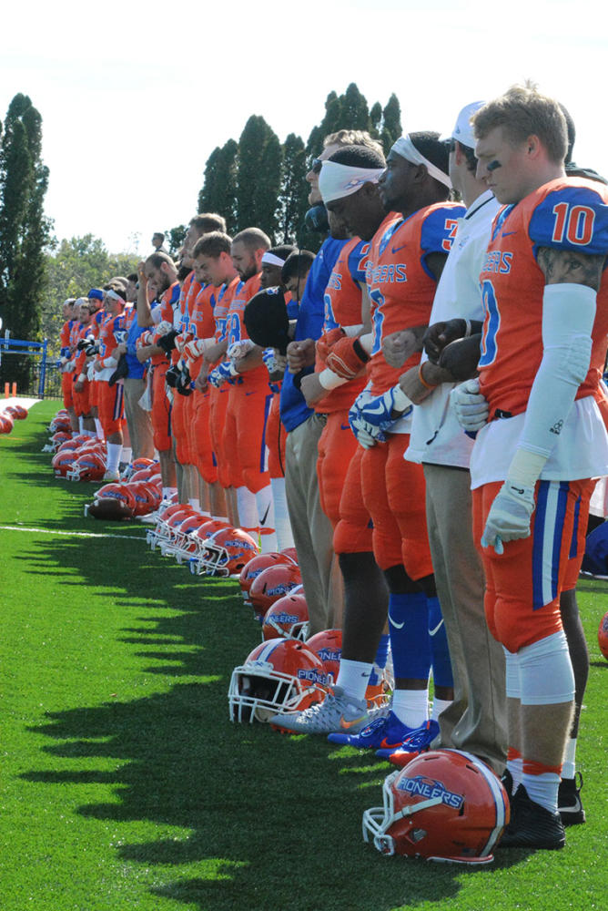 The+University+of+Wisconsin-Platteville+football+team+stands+together+with+locked+arms+during+the+national+anthem.