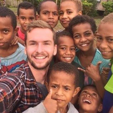 Schultz poses for pictures with children from the village he met.