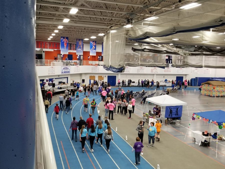 Garrison Ledbury photo
Community members and survivors walk on the fieldhouse track while game and craft stations line the inside of the court